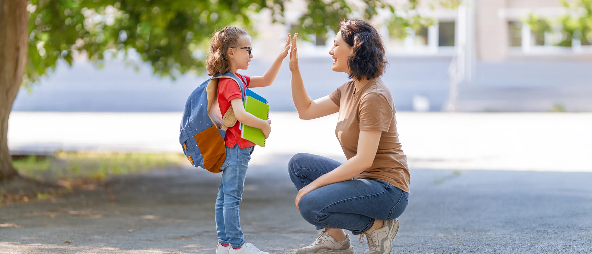 Ein Schulkind gibt ihrer Schulbegleitung einen Handschlag | © Konstantin Yuganov/Adobe Stock